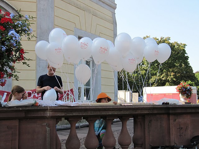 Viele weiße Luftballons hängen am Geländer am Karslruher Schloss beim Dachverband Jubiläum