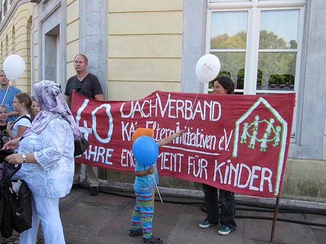 Menschen mit einem Transparent am Karslruher Schloss beim Dachverband Jubiläum