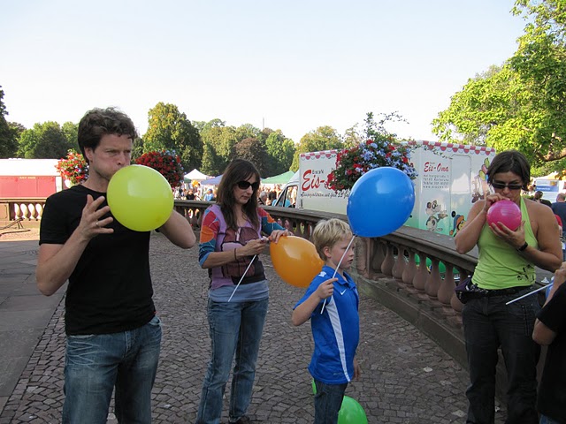 Menschen pusten bunte Luftballons auf am Karslruher Schloss beim Dachverband Jubiläum
