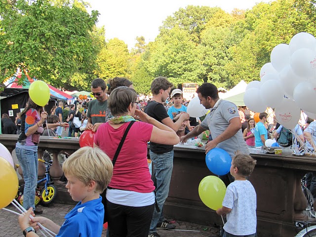 Menschen pusten bunte Luftballons auf am Karslruher Schloss beim Dachverband Jubiläum